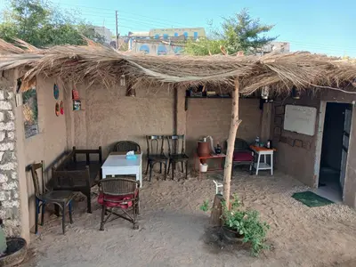 a restaurant with a table and chairs and a straw roof at Soul House in Jazīrat Fīlah