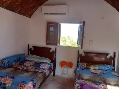 a bedroom with two beds and a window at Soul House in Jazīrat Fīlah