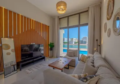 a living room with a couch and a tv at Breezy Lagoonfront Escape 3BR with Private Pool I Tawila El Gouna in Hurghada