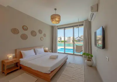a bedroom with a bed and a view of a pool at Breezy Lagoonfront Escape 3BR with Private Pool I Tawila El Gouna in Hurghada