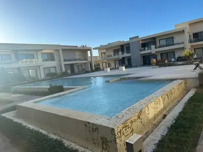 a swimming pool in front of some apartment buildings at Elgouna G cribs b-7 first floor in Hurghada