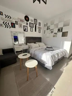 a bedroom with a bed and two tables and pictures on the wall at Elgouna G cribs b-7 first floor in Hurghada