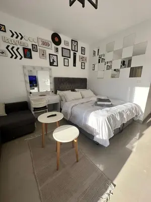 a bedroom with a bed and two tables and pictures on the wall at Elgouna g-cripes b-7 in Hurghada