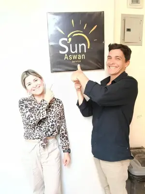 a man and a woman standing next to a sign at Sun City in Aswan