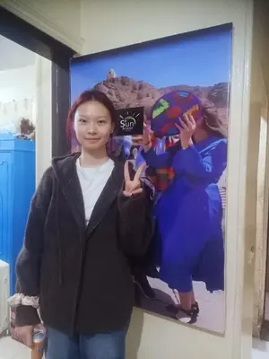a young girl standing in front of a poster at Sun City in Aswan