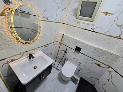 a bathroom with a sink and a mirror and a toilet at Sheraton - New & Stylish Flat in Hurghada