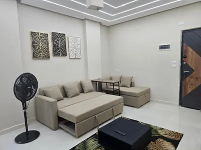 a living room with a couch and a table at Sheraton - New & Stylish Flat in Hurghada