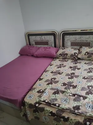 a bed with a purple comforter and pillows on it at Cozy Modern Apartament in Hurghada