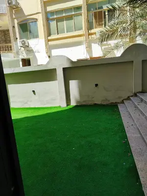 a yard of green grass in front of a building at Cozy Modern Apartament in Hurghada