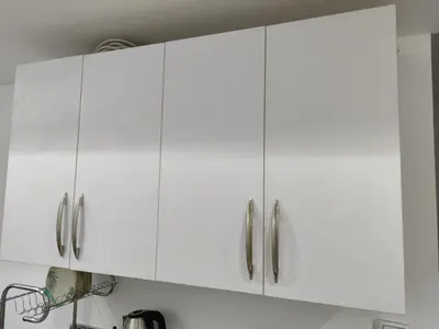 a white kitchen cabinet with silver handles at Cozy Modern Apartament in Hurghada