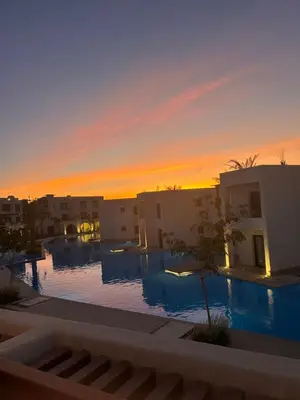 a view of a swimming pool at sunset at Tranquil 3-Bedroom Holiday Home in Makadi Heights, Hurghada - Private Rooftop Pool, Lagoon and More in Hurghada