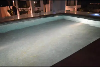 a large swimming pool in a house at night at Tranquil 3-Bedroom Holiday Home in Makadi Heights, Hurghada - Private Rooftop Pool, Lagoon and More in Hurghada