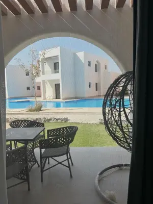 a view of a patio with a table and chairs at Tranquil 3-Bedroom Holiday Home in Makadi Heights, Hurghada - Private Rooftop Pool, Lagoon and More in Hurghada