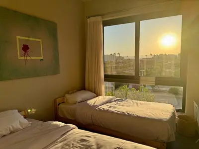 a bedroom with two beds and a window with a view at Panoramic 2BR Apt-Free Pool And Lagoon Access At ElGouna in Hurghada