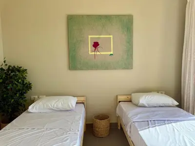 two beds in a room with a painting on the wall at Panoramic 2BR Apt-Free Pool And Lagoon Access At ElGouna in Hurghada