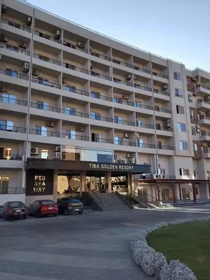 a large building with cars parked in front of it at Tiba Golden Resort Hurghada in Hurghada