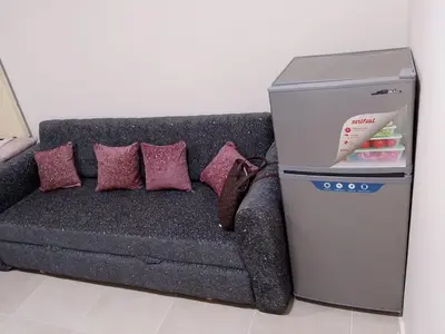 a refrigerator next to a couch with pillows at Tiba Golden Resort Hurghada in Hurghada