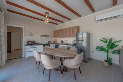 a kitchen with a table and chairs in a room at Luxury 2 Bedrooms in Bali - Elgouna with pool in Hurghada