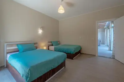 a bedroom with two beds and a hallway at Luxury 2 Bedrooms in Bali - Elgouna with pool in Hurghada