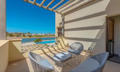 a balcony with chairs and a view of a pool at Luxury Stays in Cyan El Gouna in Hurghada