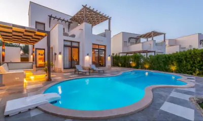 a villa with a swimming pool in front of a house at Luxury Stays in Cyan El Gouna in Hurghada