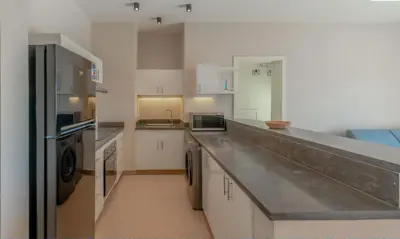 a kitchen with white cabinets and a stainless steel counter top at Luxury Stays in Cyan El Gouna in Hurghada
