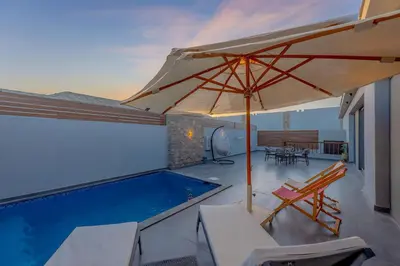 a patio with an umbrella and a swimming pool at Luxury Stays in Bali El Gouna in Hurghada