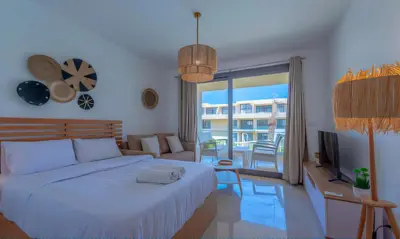 a bedroom with a white bed and a living room at Luxury Stays in G-Cribs El Gouna in El Gouna