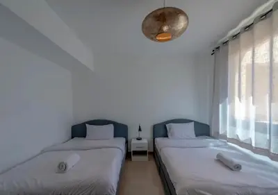 two beds in a room with white walls and a window at Luxury Stays in G-Cribs El Gouna in El Gouna