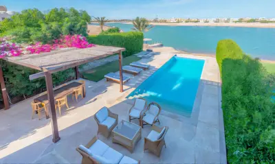 an overhead view of a swimming pool with chairs and a table at Luxury Stays in Sabina El Gouna in Hurghada