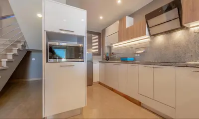 a kitchen with white cabinets and a staircase at Luxury Stays in Sabina El Gouna in Hurghada
