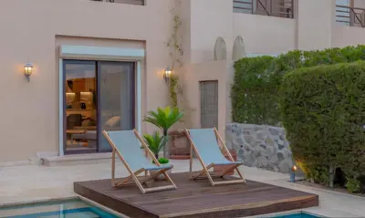two chairs sitting on a deck next to a pool at Luxury Stays in Sabina El Gouna in Hurghada