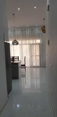 a living room with a kitchen and a table and a window at Jahmed Country Villa Luxor West Bank in Al Aqālitah