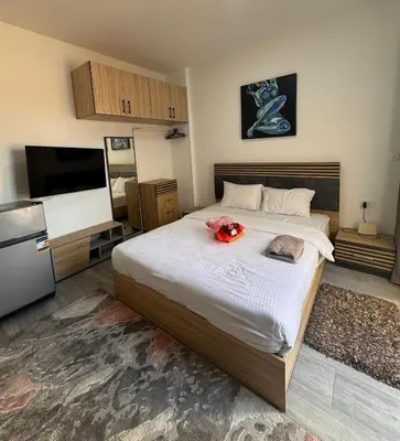 a bedroom with a large bed and a flat screen tv at Studio 511 imperial resort in Hurghada
