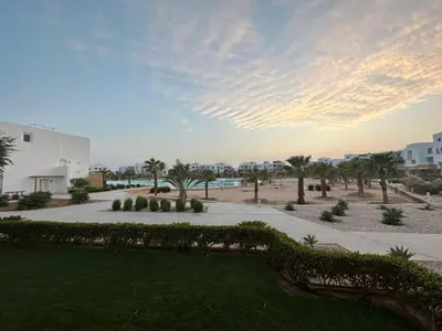 a view of a park with palm trees and a building at Ground Modern Apartment in Hurghada