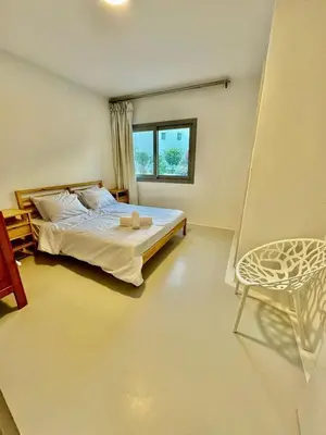a bedroom with a bed and a window and a chair at Ground Modern Apartment in Hurghada