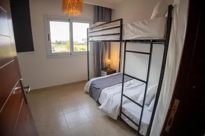 a bedroom with two bunk beds and a window at Breeze, Golf & Sea, 2 BR Luxury Apt with Terrace, Somabay in Hurghada