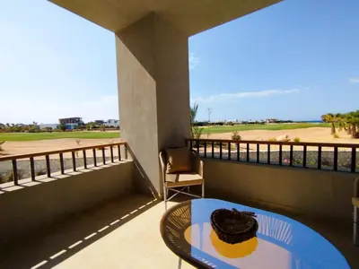 a cake sitting on a table on a balcony at Breeze, Golf & Sea, 2 BR Luxury Apt with Terrace, Somabay in Hurghada