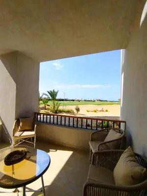 a room with a balcony with a table and chairs at Breeze, Golf & Sea, 2 BR Luxury Apt with Terrace, Somabay in Hurghada