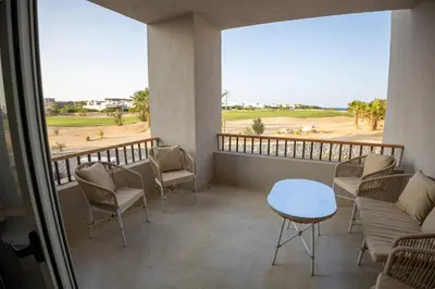 a balcony with chairs and a table and a view at Breeze, Golf & Sea, 2 BR Luxury Apt with Terrace, Somabay in Hurghada