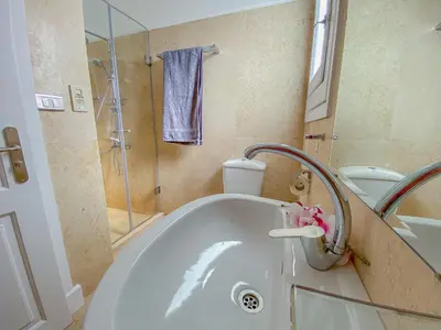 a bathroom with a tub with a shower and a sink at Modern 2 bedroom apartment in El Gouna with pool in Hurghada