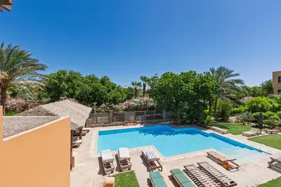 a pool with chaise lounge chairs and a resort at Modern 2 bedroom apartment in El Gouna with pool in Hurghada