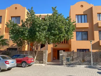 two cars parked in a parking lot in front of a building at Modern 2 bedroom apartment in El Gouna with pool in Hurghada