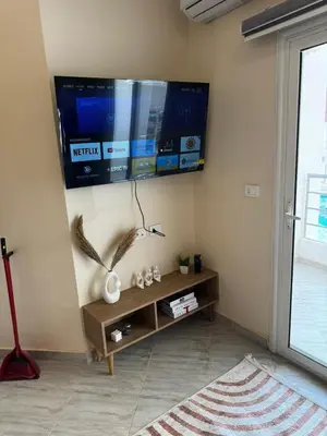 a living room with a flat screen tv on the wall at Aqua Palms Resort Hurghada in Hurghada