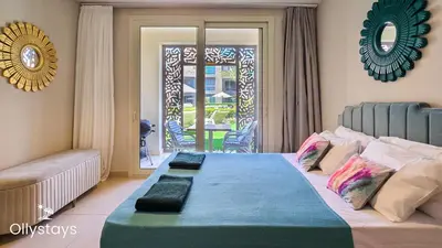 a bedroom with a bed with a couch and a window at Ollystays Mangroovy Seaview 1BR Beach and Pool Free access in Hurghada