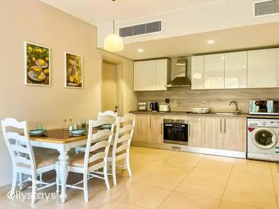 a kitchen with a table and chairs in a room at Ollystays Mangroovy Seaview 1BR Beach and Pool Free access in Hurghada