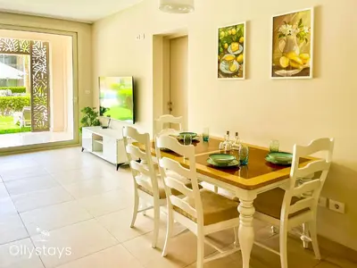 a dining room with a wooden table and chairs at Ollystays Mangroovy Seaview 1BR Beach and Pool Free access in Hurghada