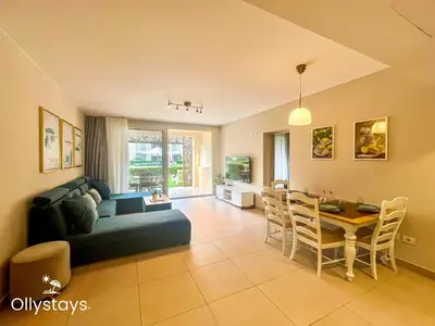 a living room with a blue couch and a table at Ollystays Mangroovy Seaview 1BR Beach and Pool Free access in Hurghada