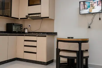 a kitchen with a bar stool and a microwave at Hurghada HUB Resort in Hurghada