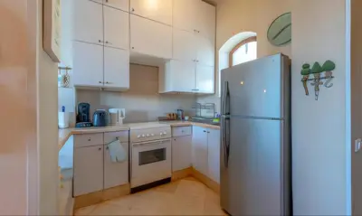 a kitchen with white cabinets and a refrigerator at Luxury Stays in Nubia El Gouna in Hurghada